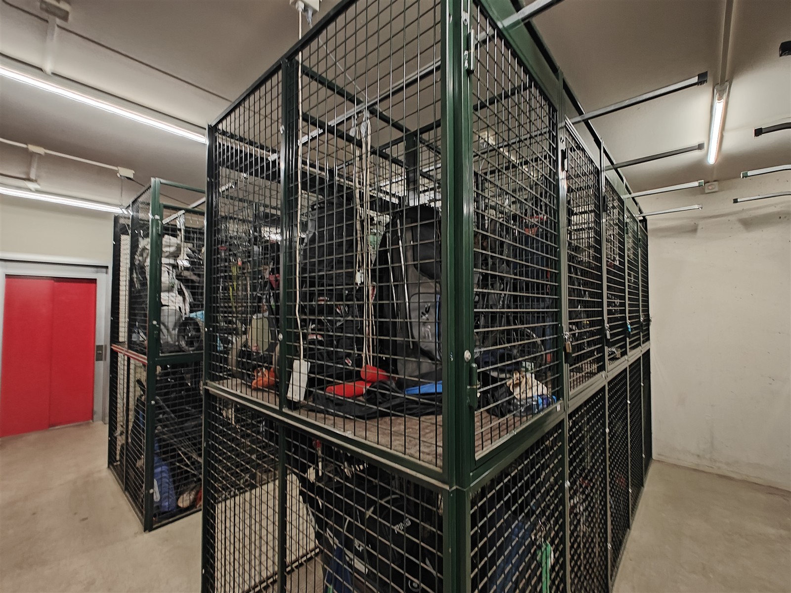 Gestapelde trolleykooien met golftassen, trolleys en sportspullen in een golfclub